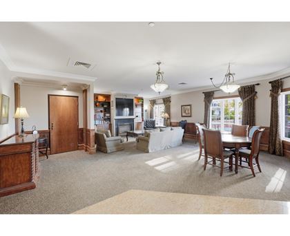A spacious living room with a dining table and chairs.