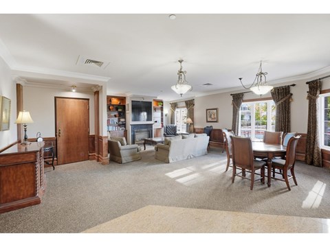 A spacious living room with a dining table and chairs.