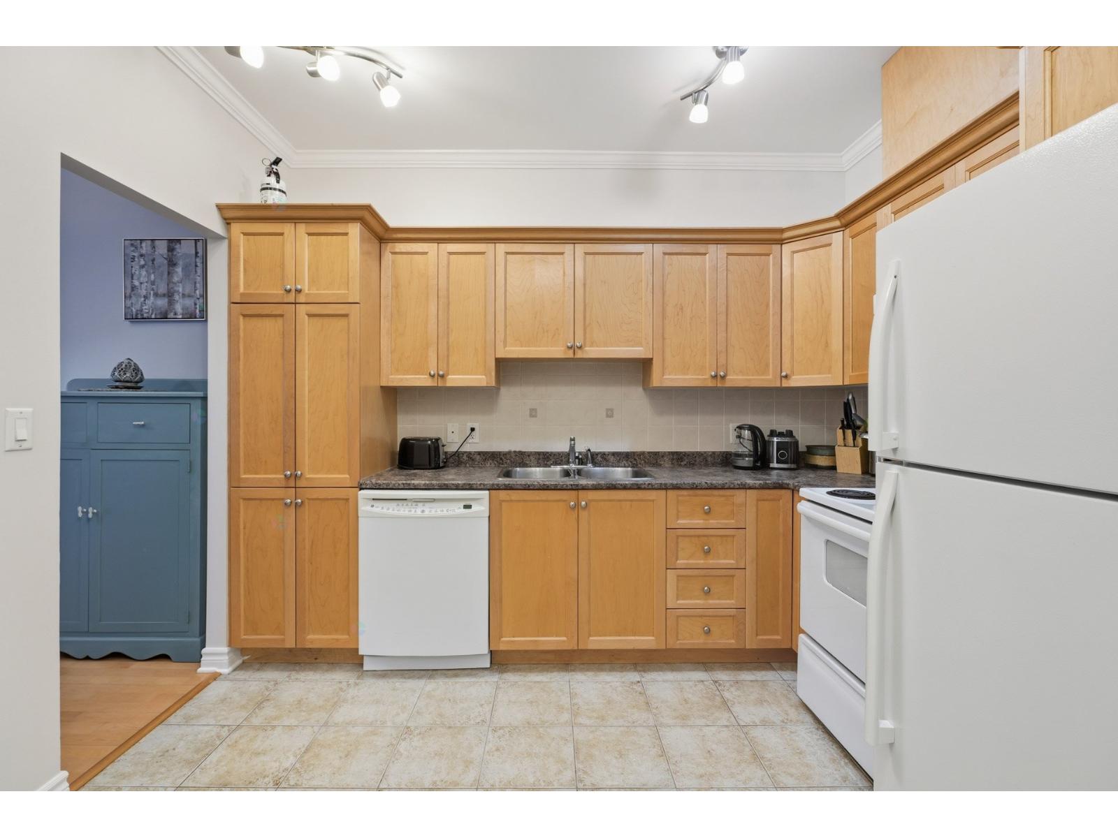 A kitchen with wooden cabinets and a white refrigerator.