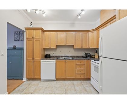 A kitchen with wooden cabinets and a white refrigerator.