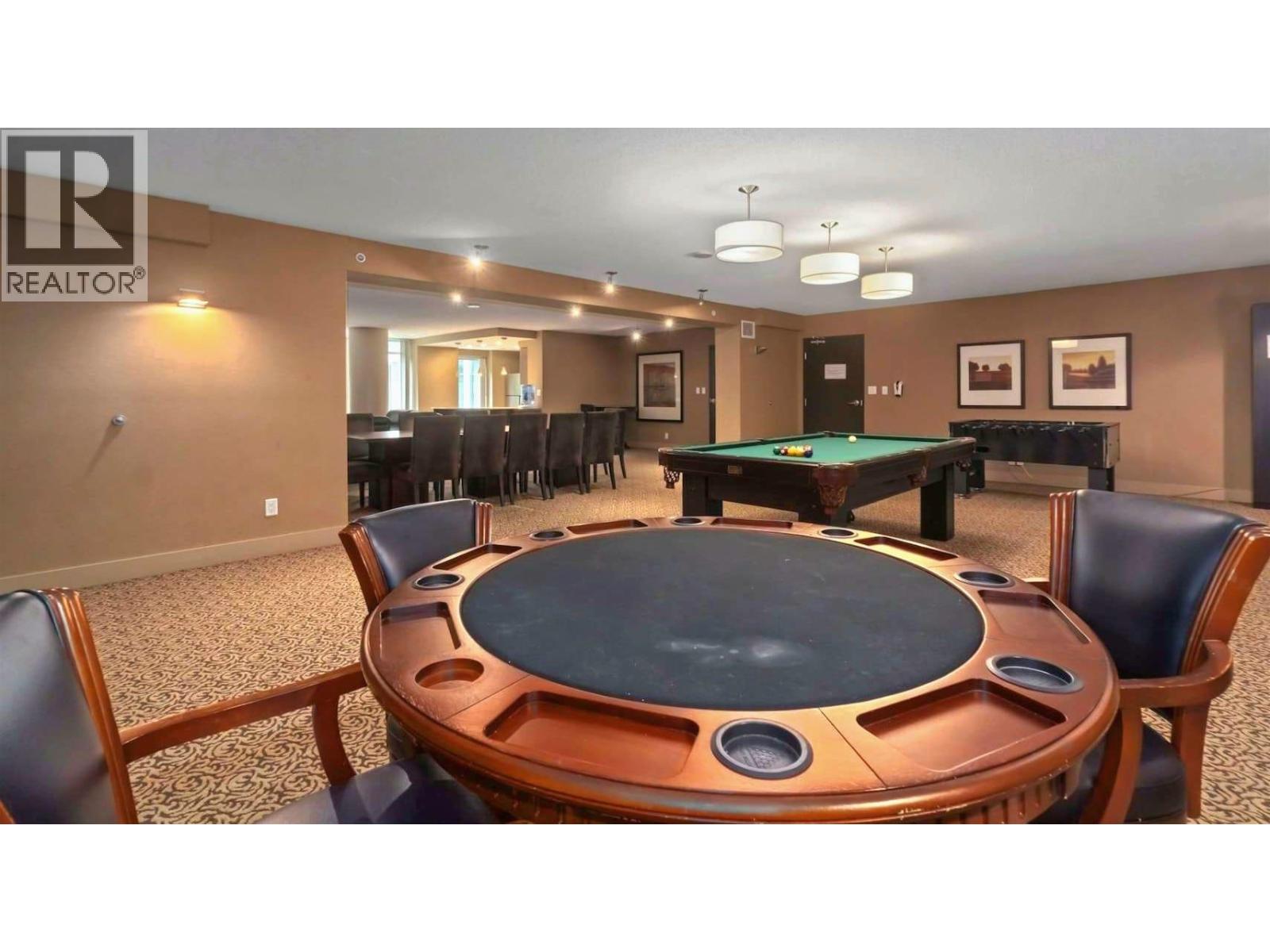 A pool table in a room with a brown table and chairs.