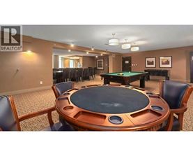 A pool table in a room with a brown table and chairs.