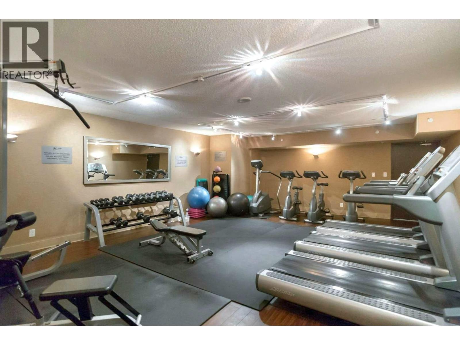 A gym with treadmills, weights, and exercise balls.