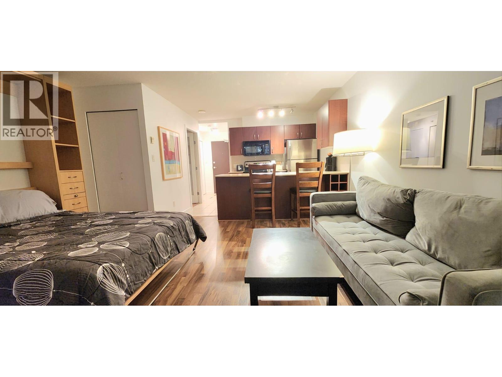 A bedroom with a bed, a couch, and a coffee table.