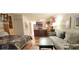 A bedroom with a bed, a couch, and a coffee table.