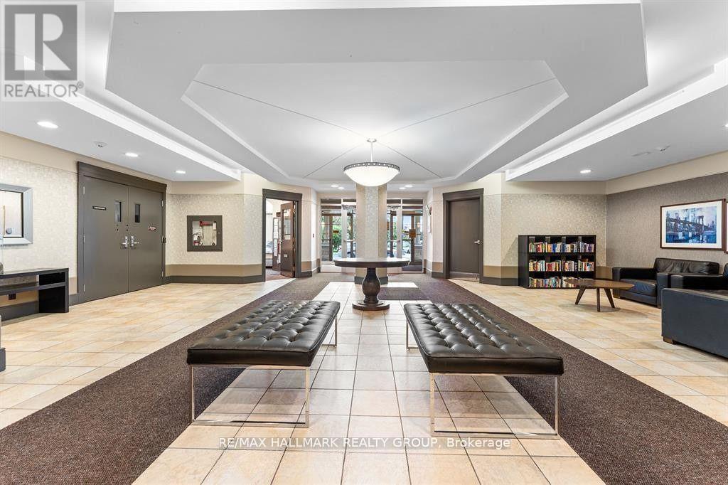 A spacious lobby with a bench in the middle of the room.