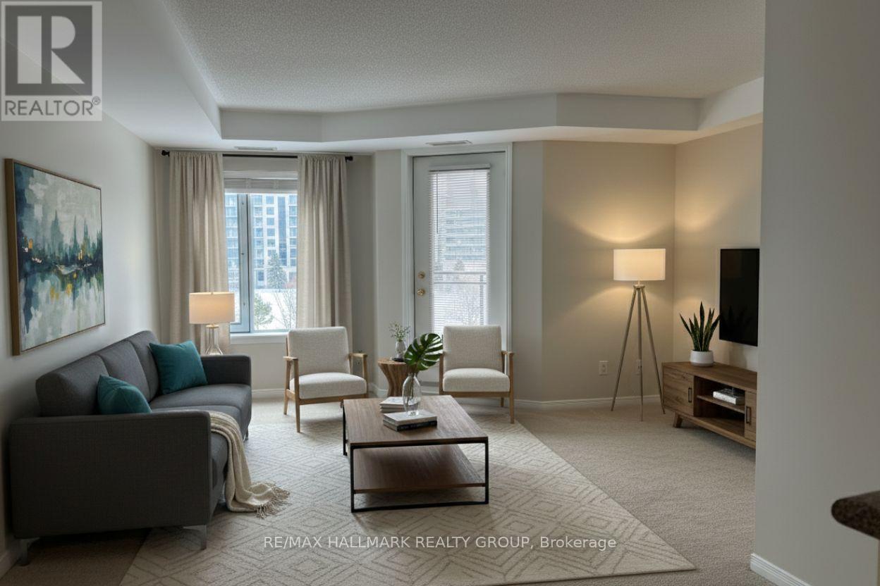 A living room with a grey couch, a white chair, a coffee table, and a painting on the wall.