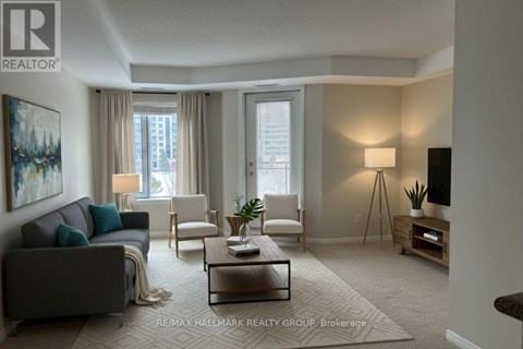 A living room with a grey couch, a white chair, a coffee table, and a painting on the wall.