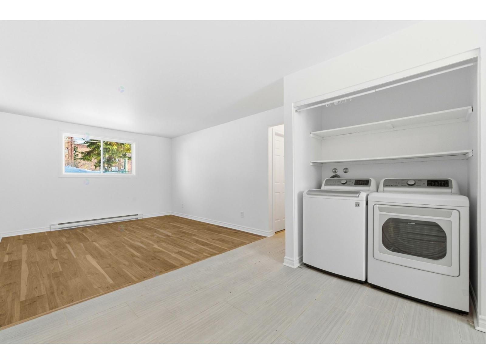 A kitchen area with a white oven and a window with a view of trees.