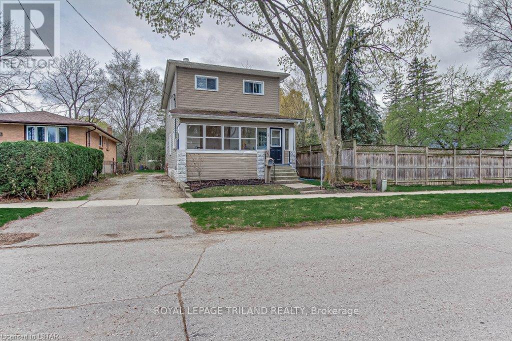 A house with a grey roof and a white fence in front.