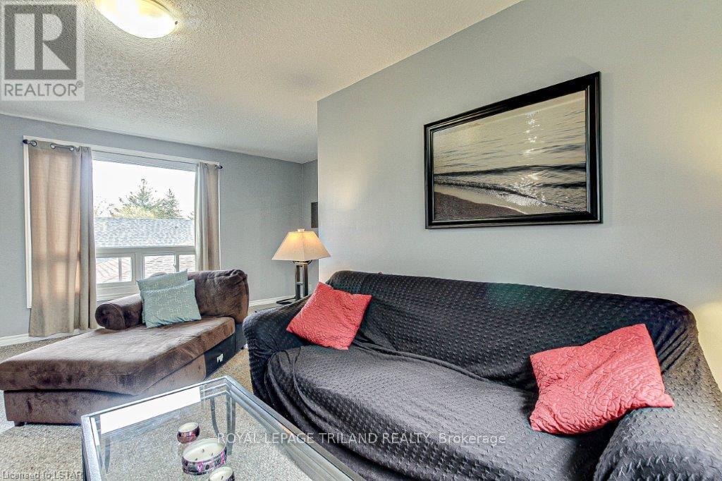 A living room with a grey couch, a coffee table, and a painting on the wall.