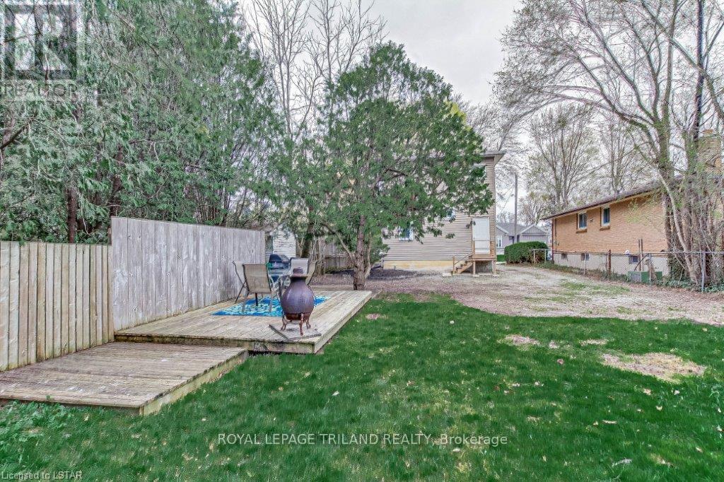 A backyard with a deck and a hot tub.