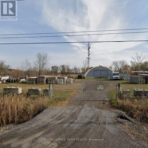 A dirt road leads to a gate with a sign that says "ROYAL LEPAGE TEAM REALTY Brokerage.".