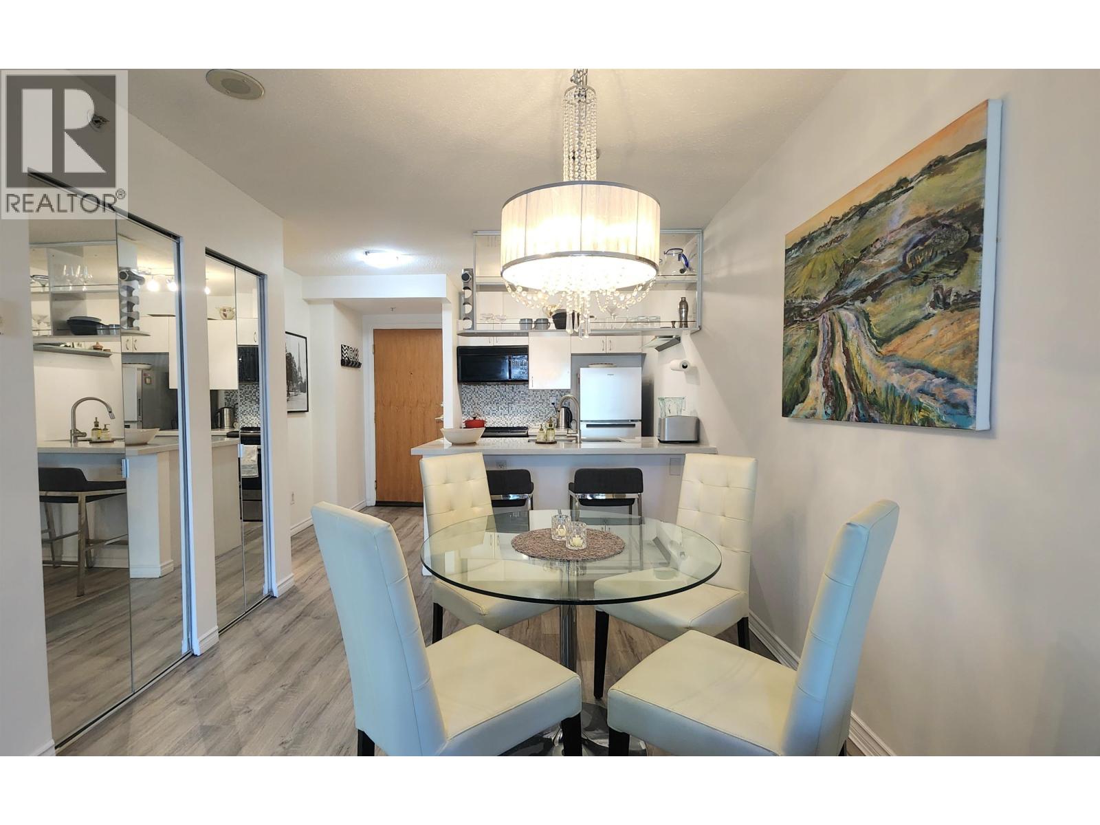 A dining room with a glass table and chairs.