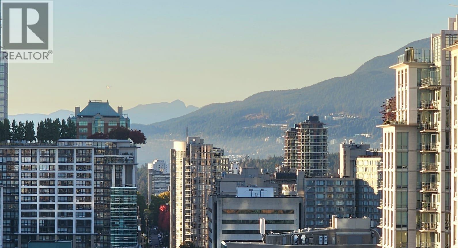 A cityscape with buildings and a mountain in the background.