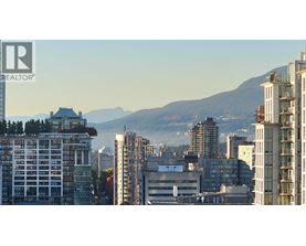 A cityscape with buildings and a mountain in the background.