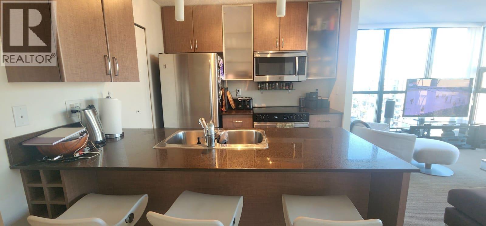A kitchen with a sink and refrigerator.