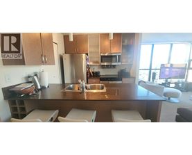 A kitchen with a sink and refrigerator.