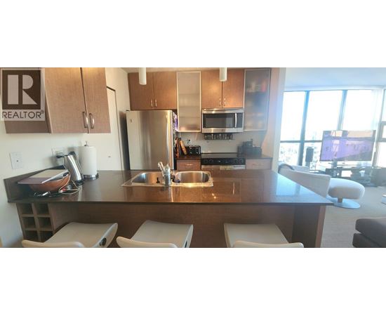 A kitchen with a sink and refrigerator.
