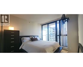 A bedroom with a large bed and a sliding glass door.