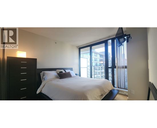 A bedroom with a large bed and a sliding glass door.