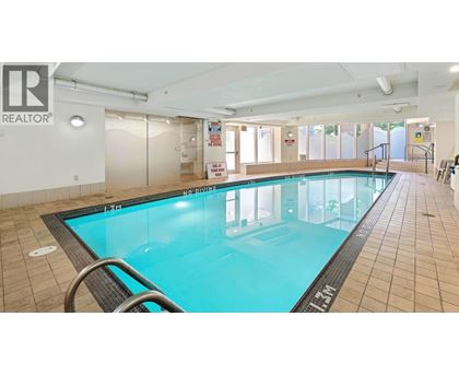 A large indoor swimming pool with a glass wall on one side.