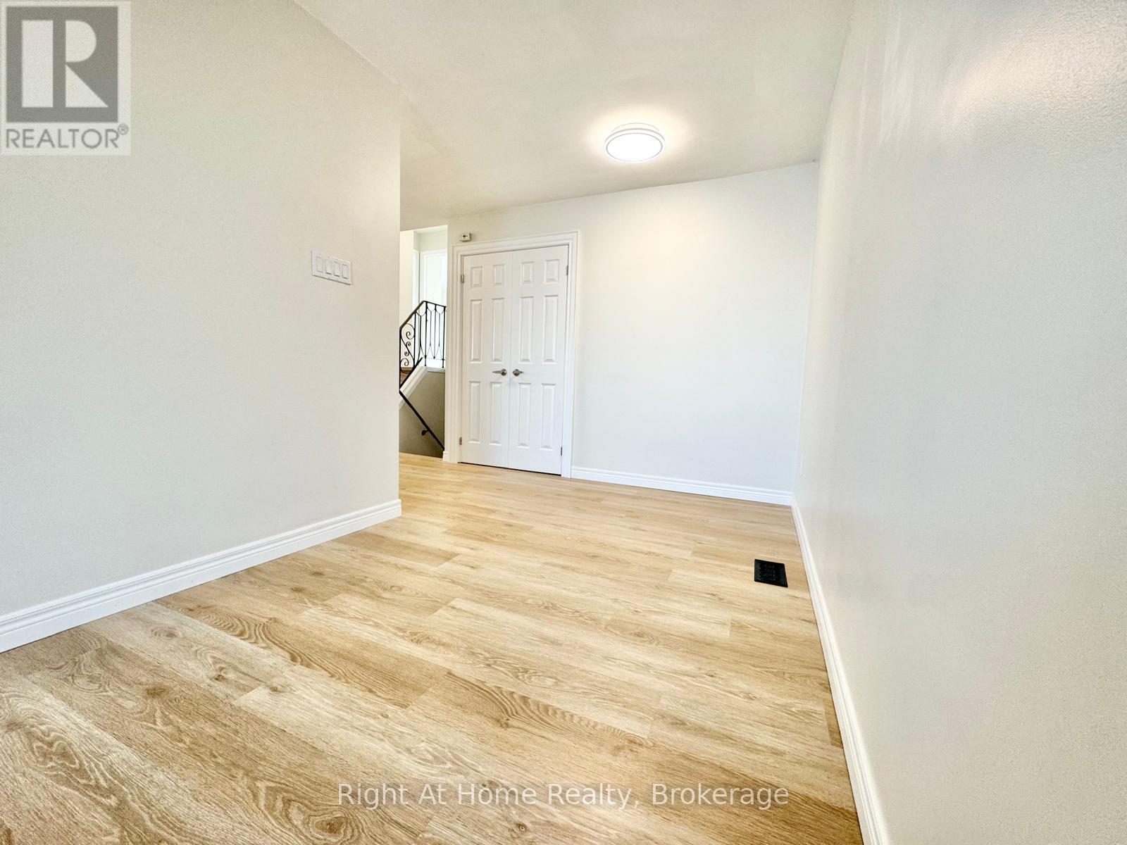 A room with wooden flooring and a white door.