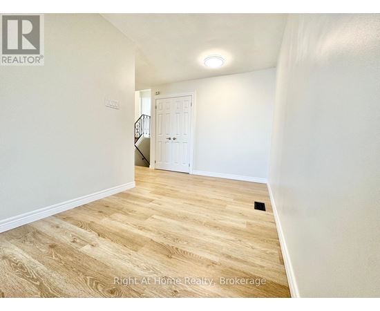 A room with wooden flooring and a white door.