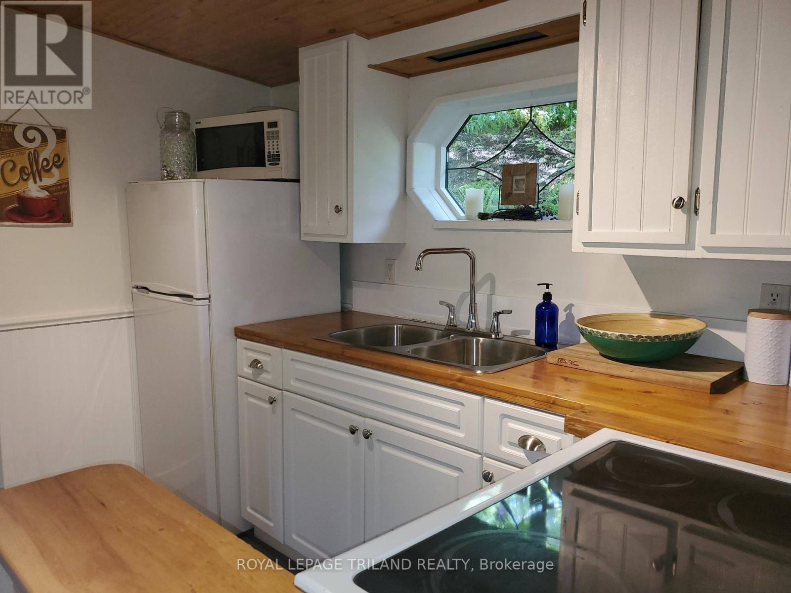 A kitchen with white cabinets and a wooden countertop.