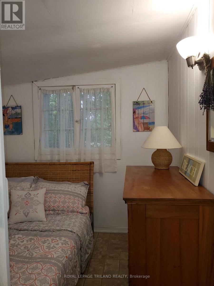 A bedroom with a bed, nightstand, and lamp.