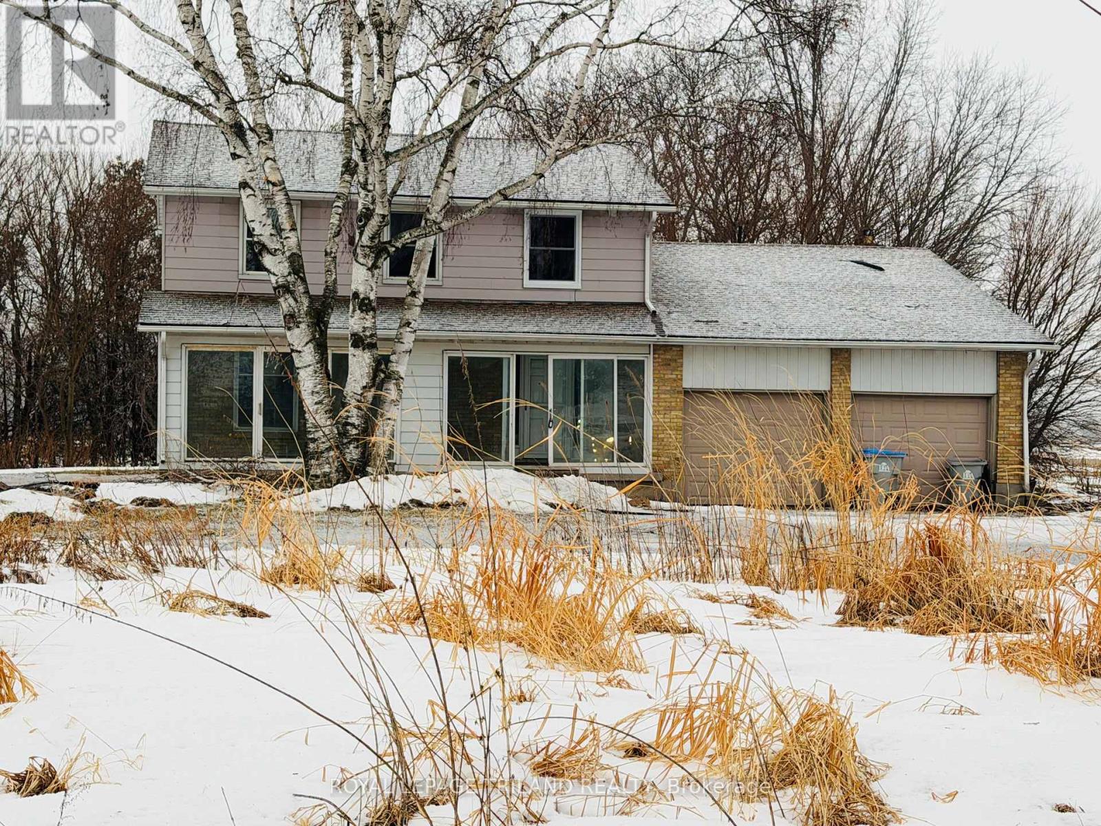 A house with a snowy landscape in front of it.