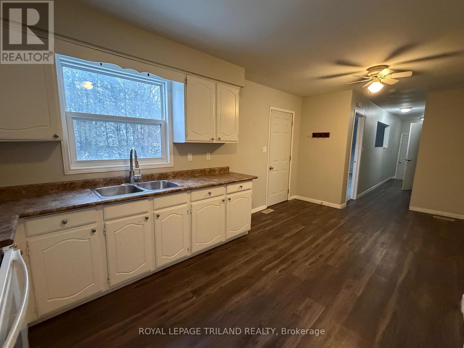 A kitchen with white cabinets and a brown countertop.