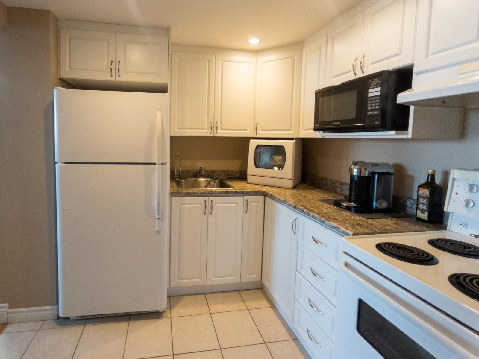 A kitchen with white appliances and cabinets.