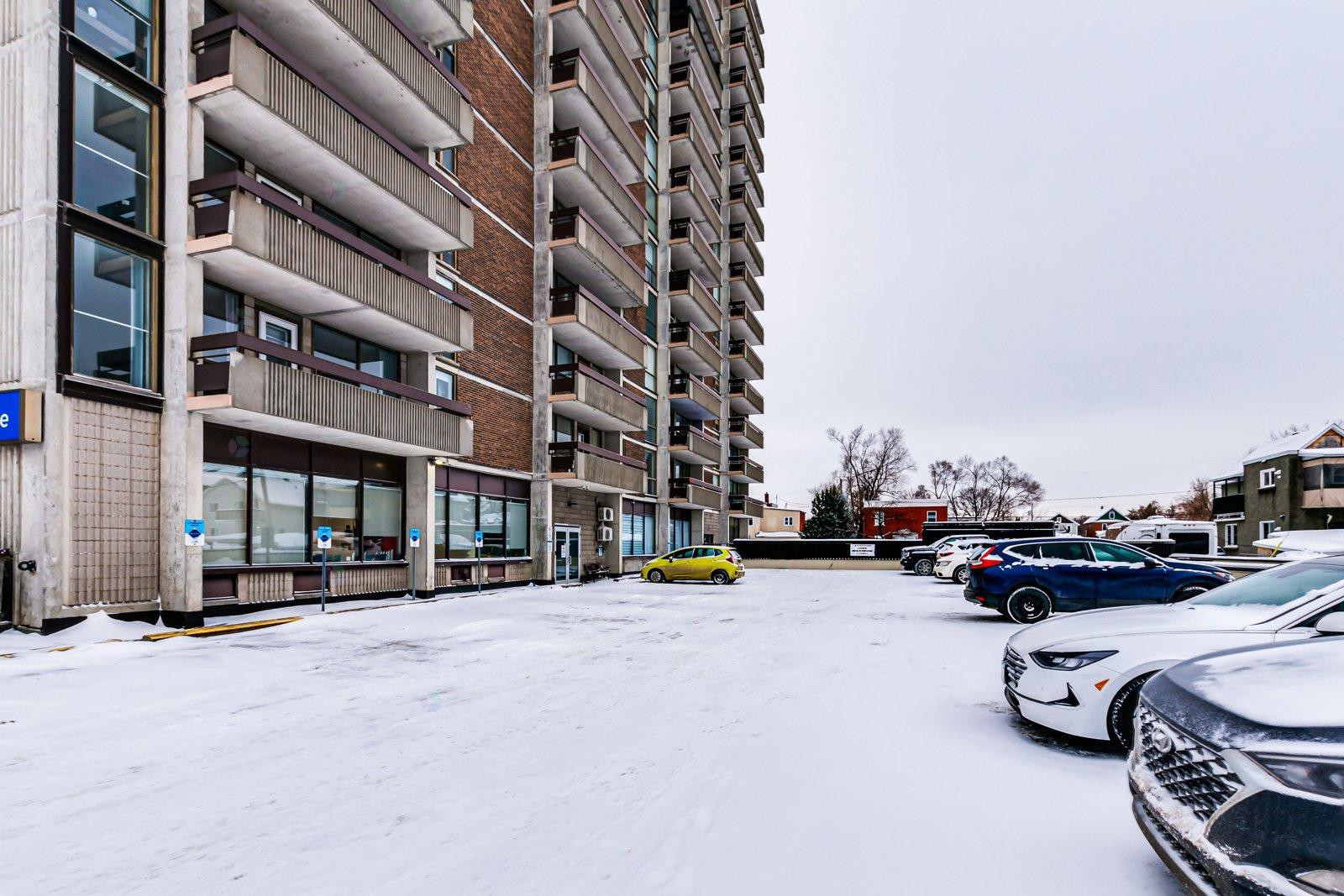 A parking lot with cars and a building in the background.