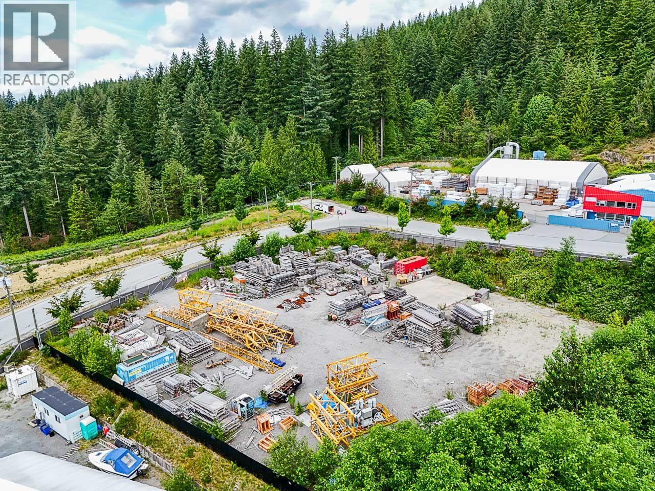 A large outdoor storage area with various items and a building in the background.