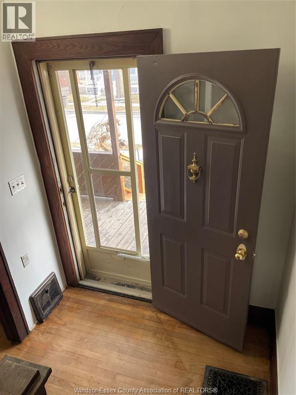 A brown door with a glass window is in a room.