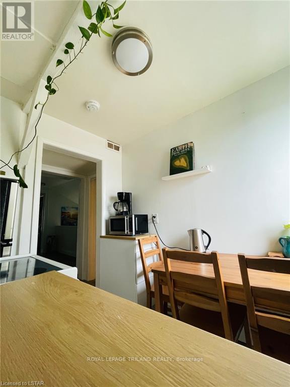 A dining room with a wooden table and chairs.