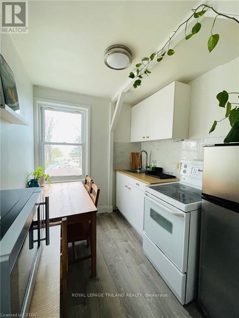 A kitchen with a table and chairs by a window.
