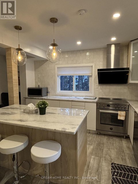 A kitchen with a marble countertop and a stove top oven.