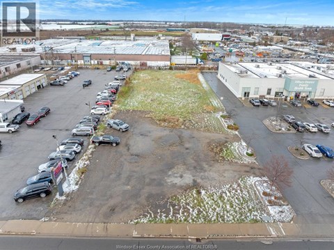 A parking lot with a grassy area in the middle and several cars parked.