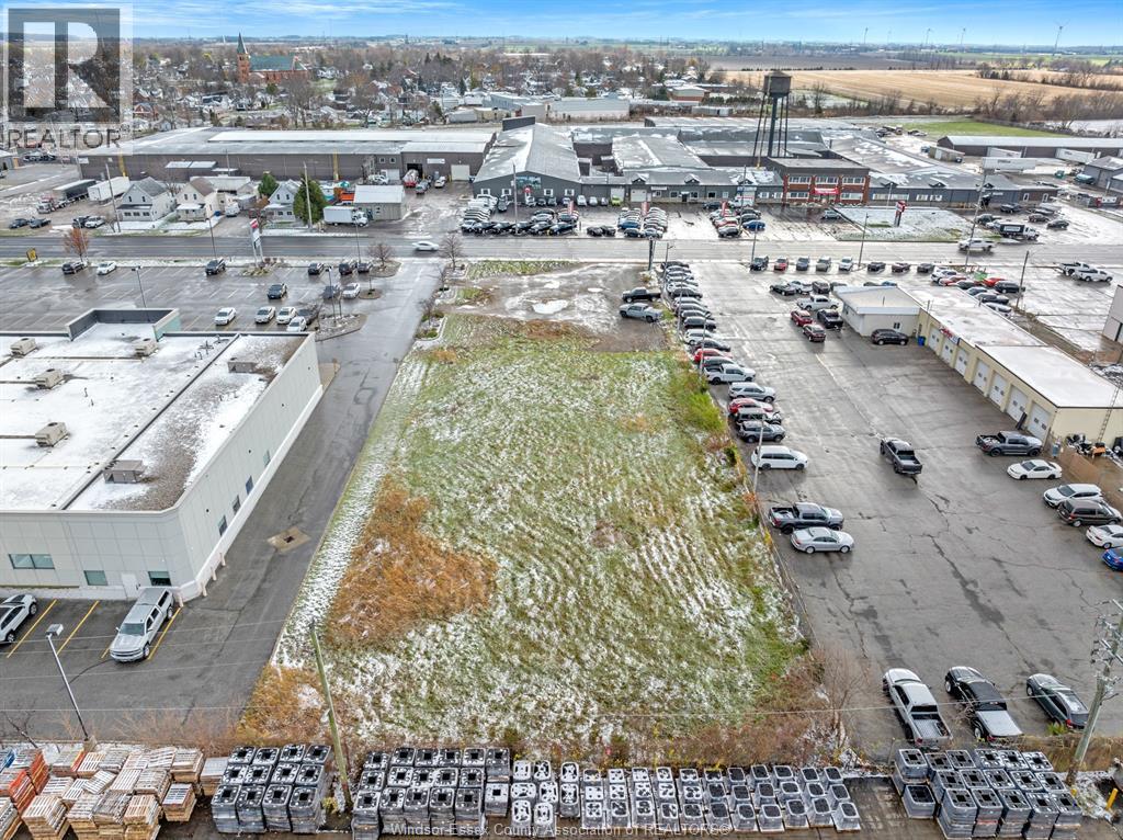 A parking lot with cars and trucks is surrounded by buildings.