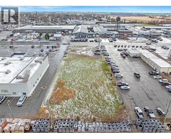 A parking lot with cars and trucks is surrounded by buildings.