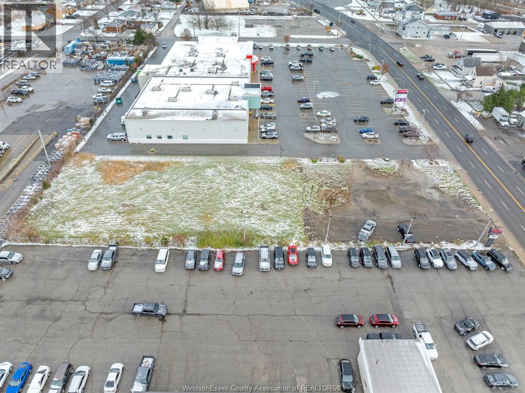 A parking lot with cars and a building in the background.
