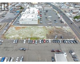 A parking lot with cars and a building in the background.