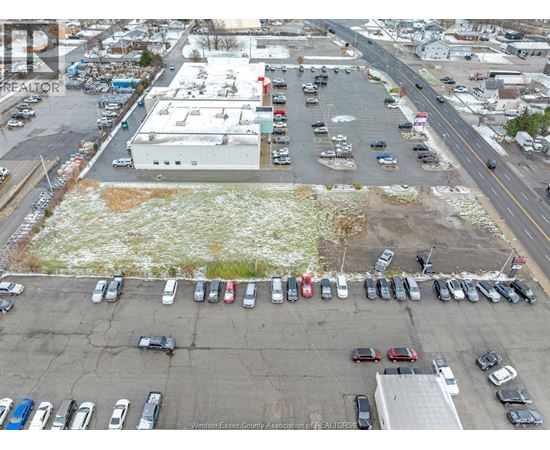 A parking lot with cars and a building in the background.