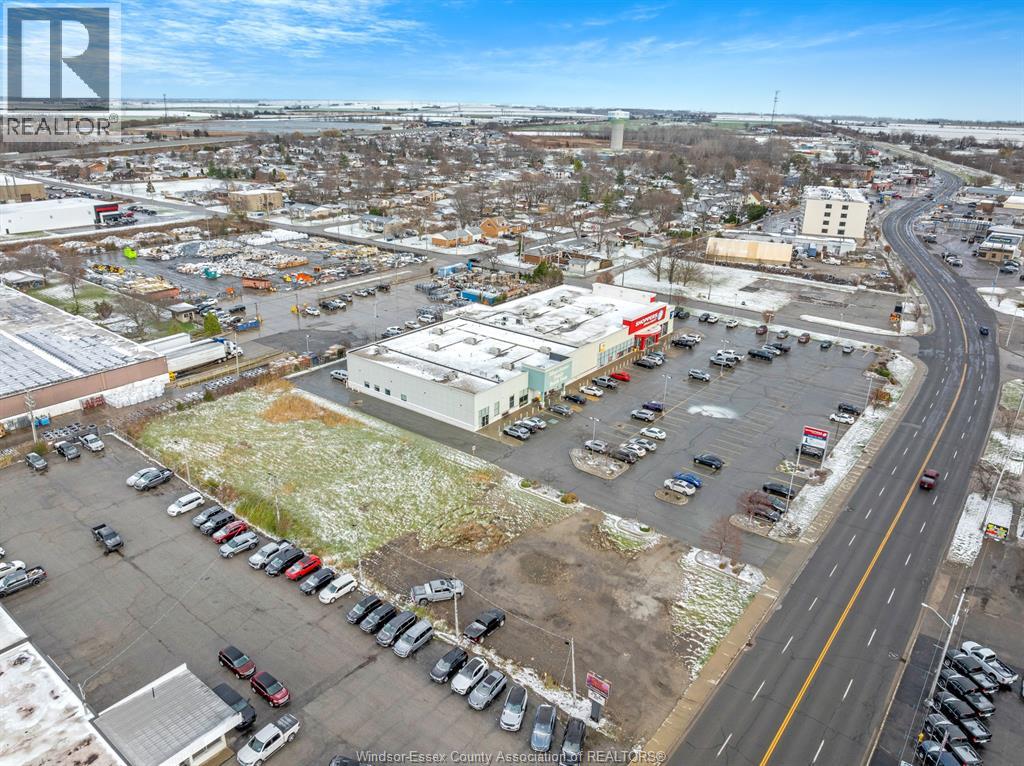 A parking lot with cars and a road running through it.