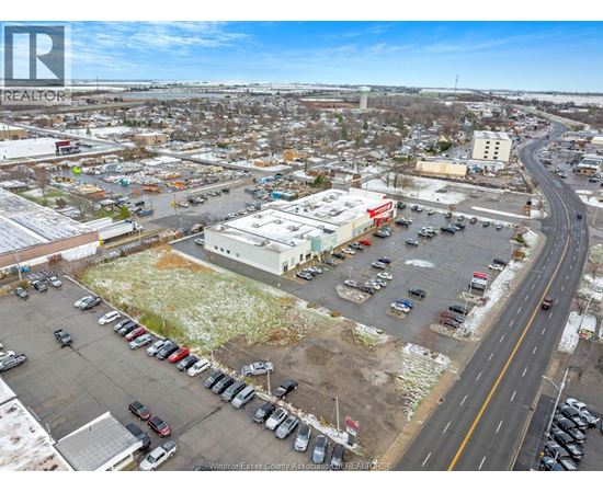 A parking lot with cars and a road running through it.