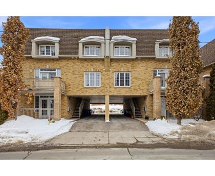 A large brick building with a garage underneath the entrance.