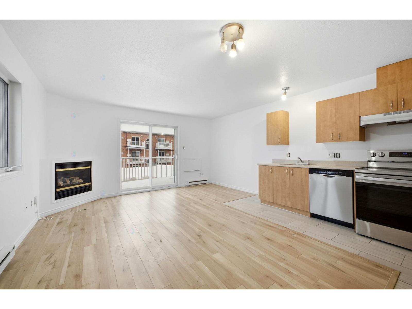 A spacious living room with a fireplace and wooden flooring.