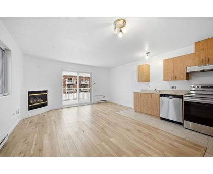 A spacious living room with a fireplace and wooden flooring.
